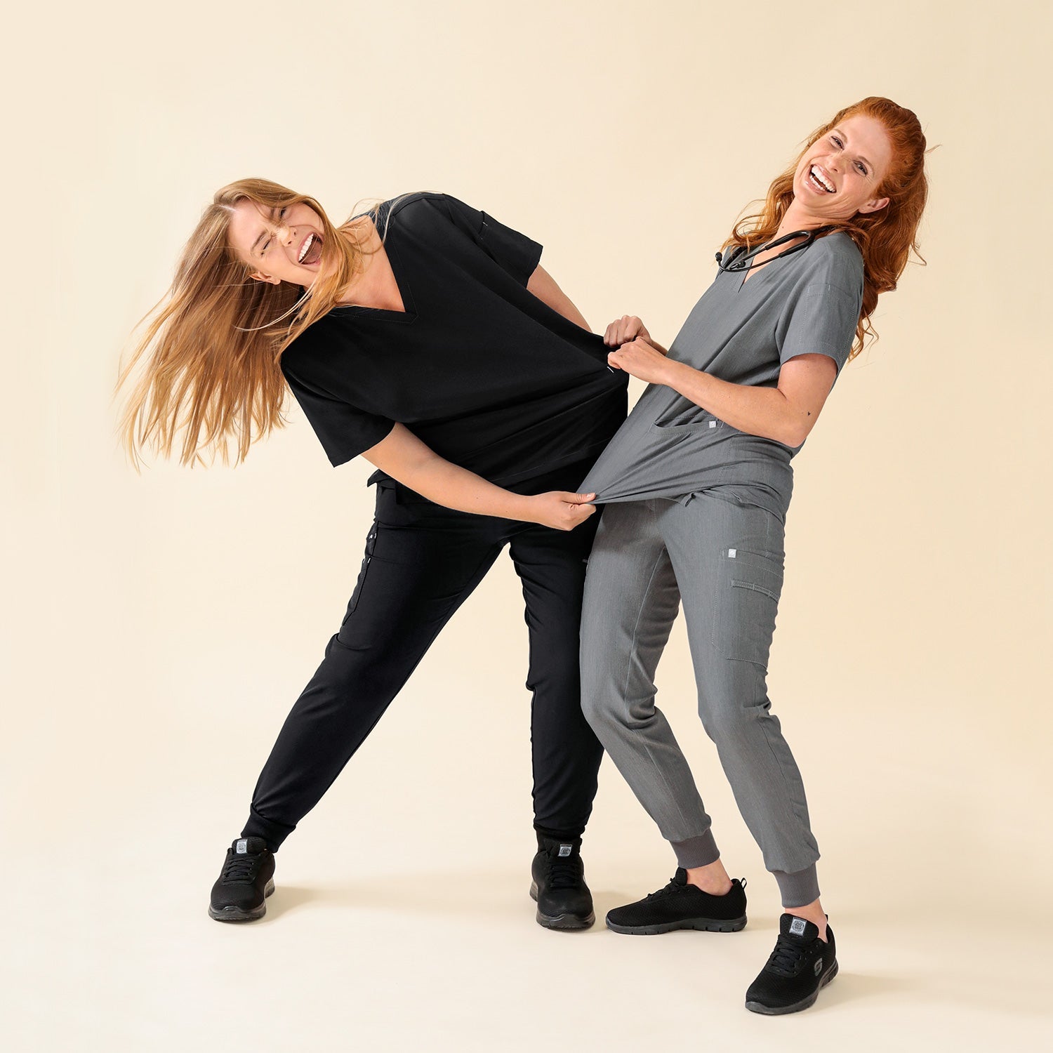 KAERE Outfits, 2 weibliche Models reißen gegenseitig am Schlupfkasack um den Stretch-Effekt zu präsentieren.