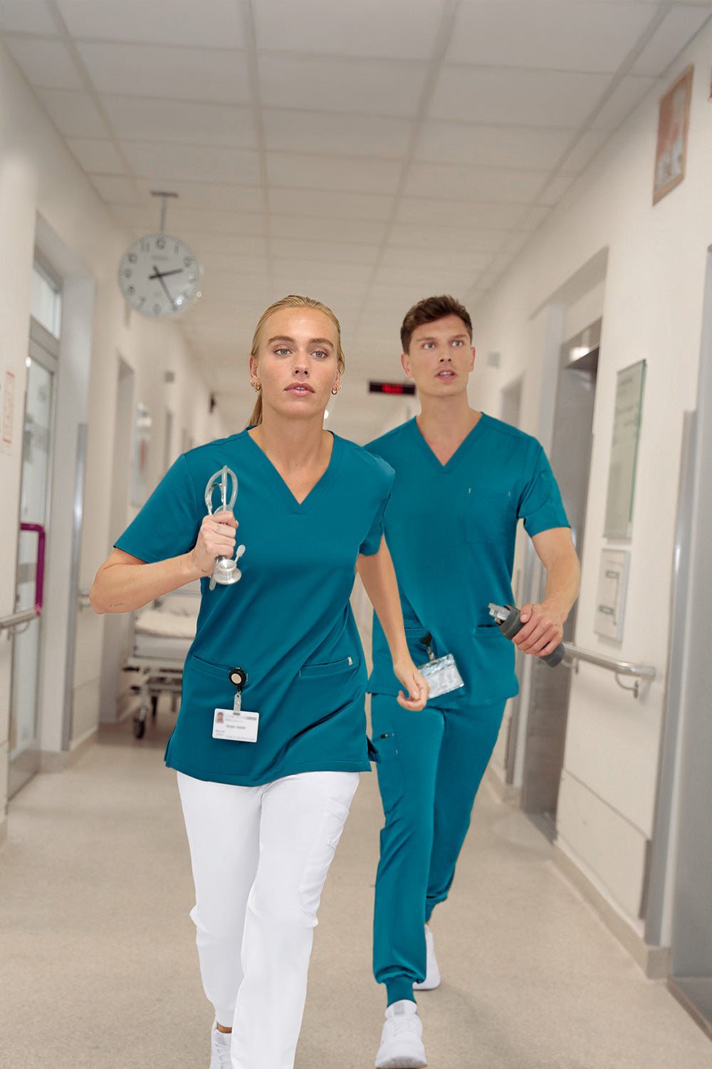 KAERE Schlupfkasacks in Petrol, Damen- und Herren Model rennen im Krankenhaus den Flur hinunter.